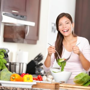 Woman making salad in kitchen